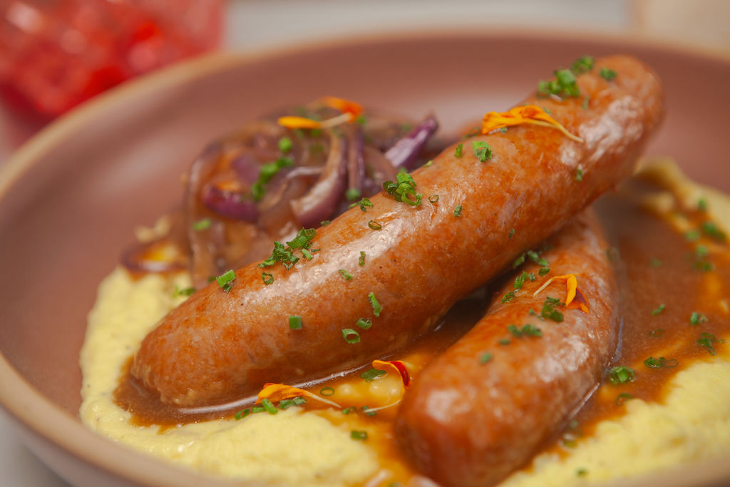 Sausages on creamy polenta with caramelized onions